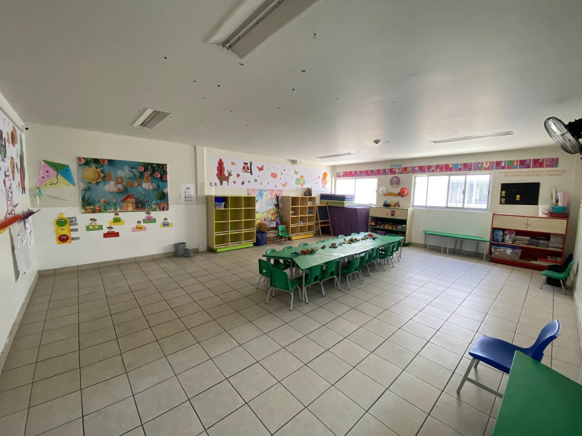 Una de nuestras aulas, con mesas infantiles y materiales de actividades